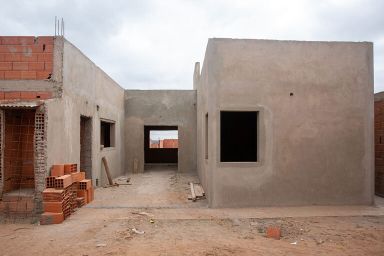 Fachada en construcción de casa contemporánea para una pareja joven en Neuquén