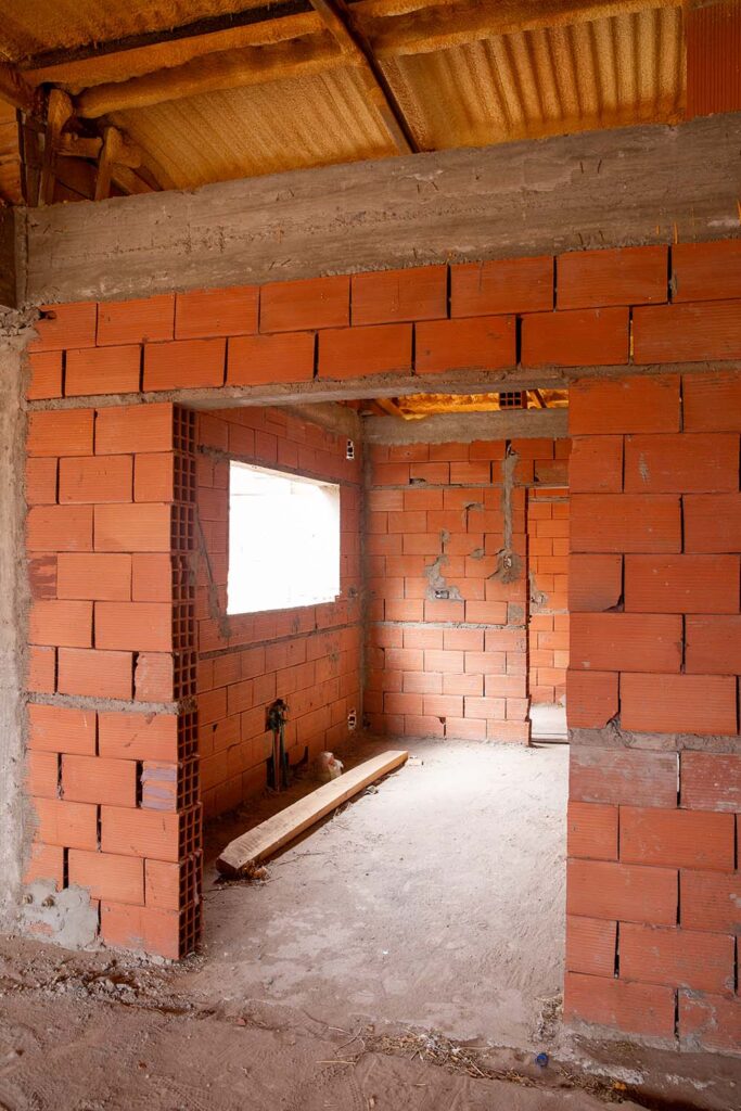 Interior en obra de casa para una pareja joven en Neuquén, muro de ladrillo